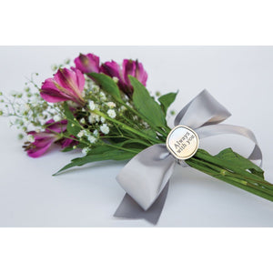 3 of 3:Always with you coin resting on a bouquet of flowers.