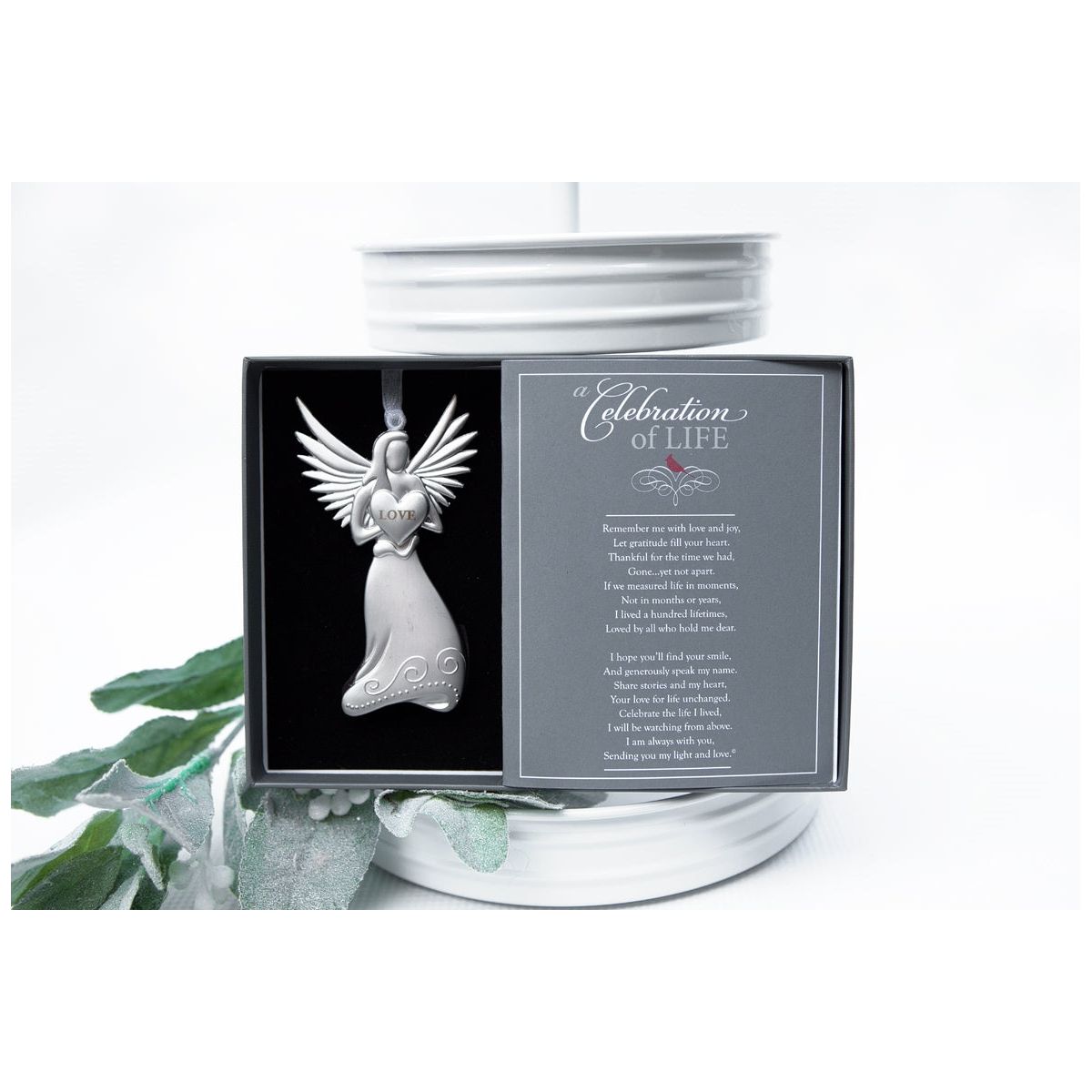 Silver toned metal angel is holding a heart with the word "LOVE" and has a white organza ribbon for hanging.