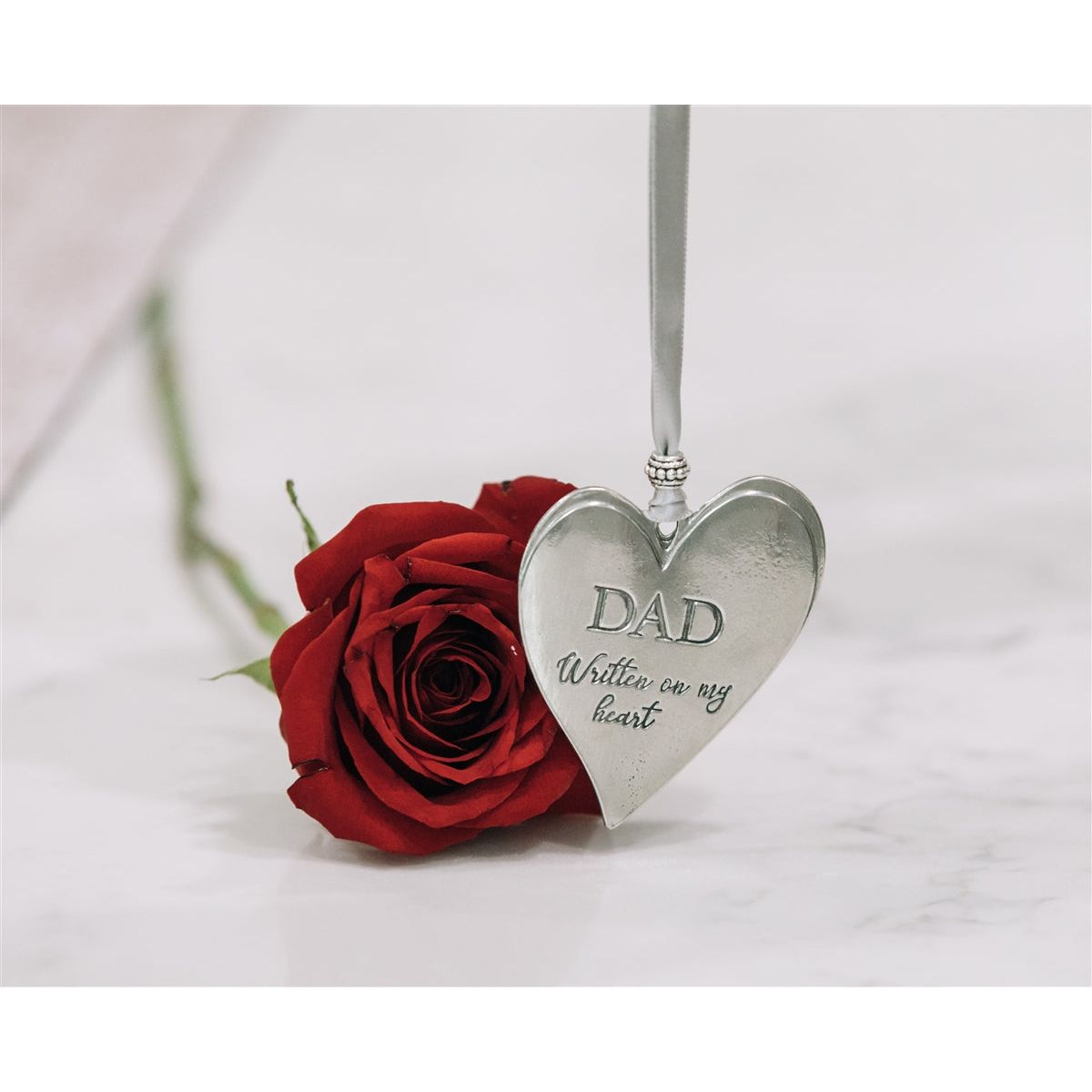 Dad pewter heart hanging from gray satin ribbon.