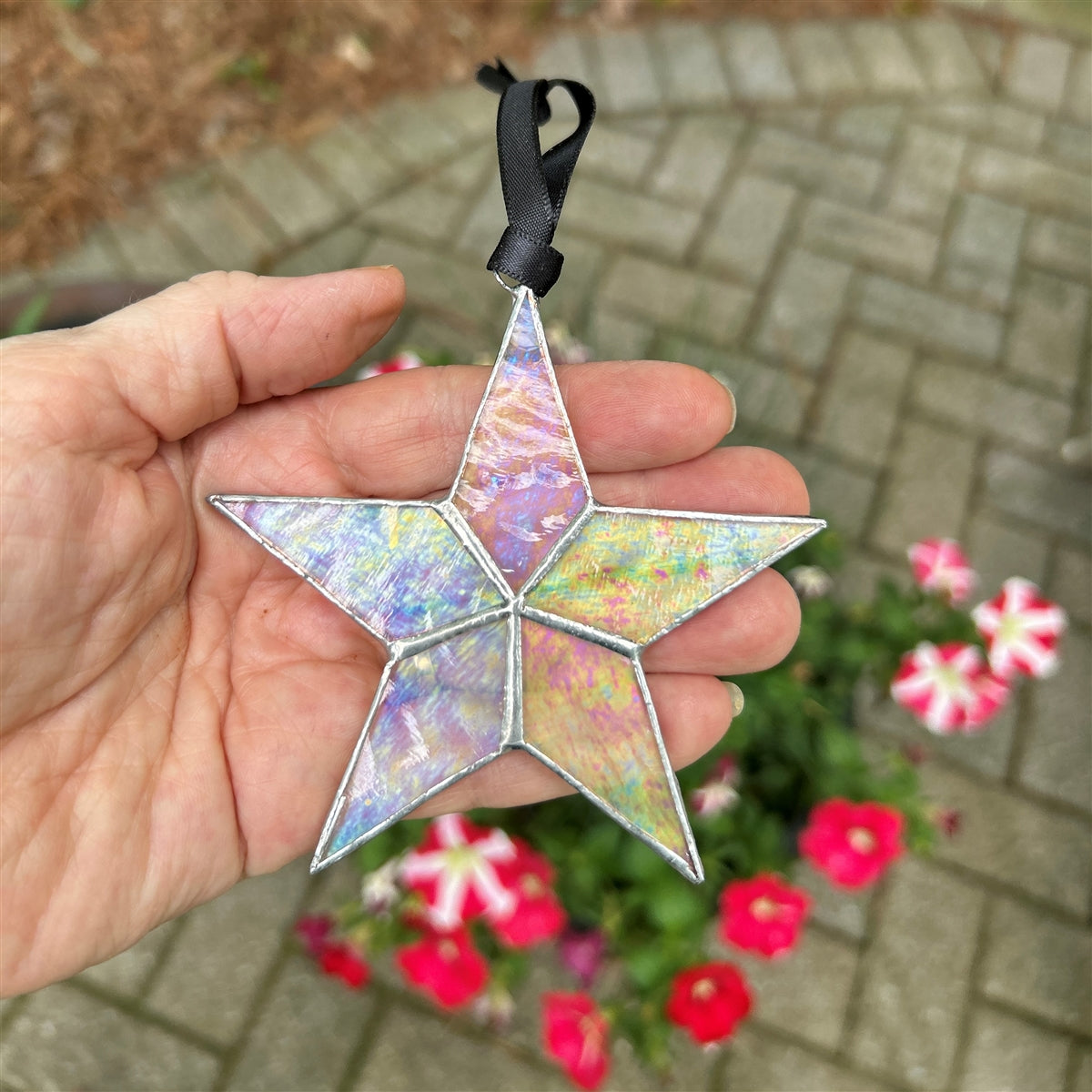 Clear iridescent star being held in hand.