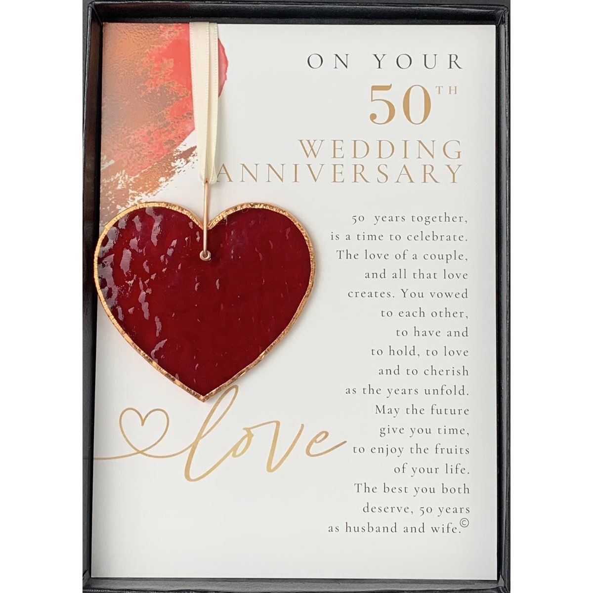 Stained glass red heart edged with copper and packaged with "On Your 50th Wedding Anniversary" sentiment in black box with clear lid.