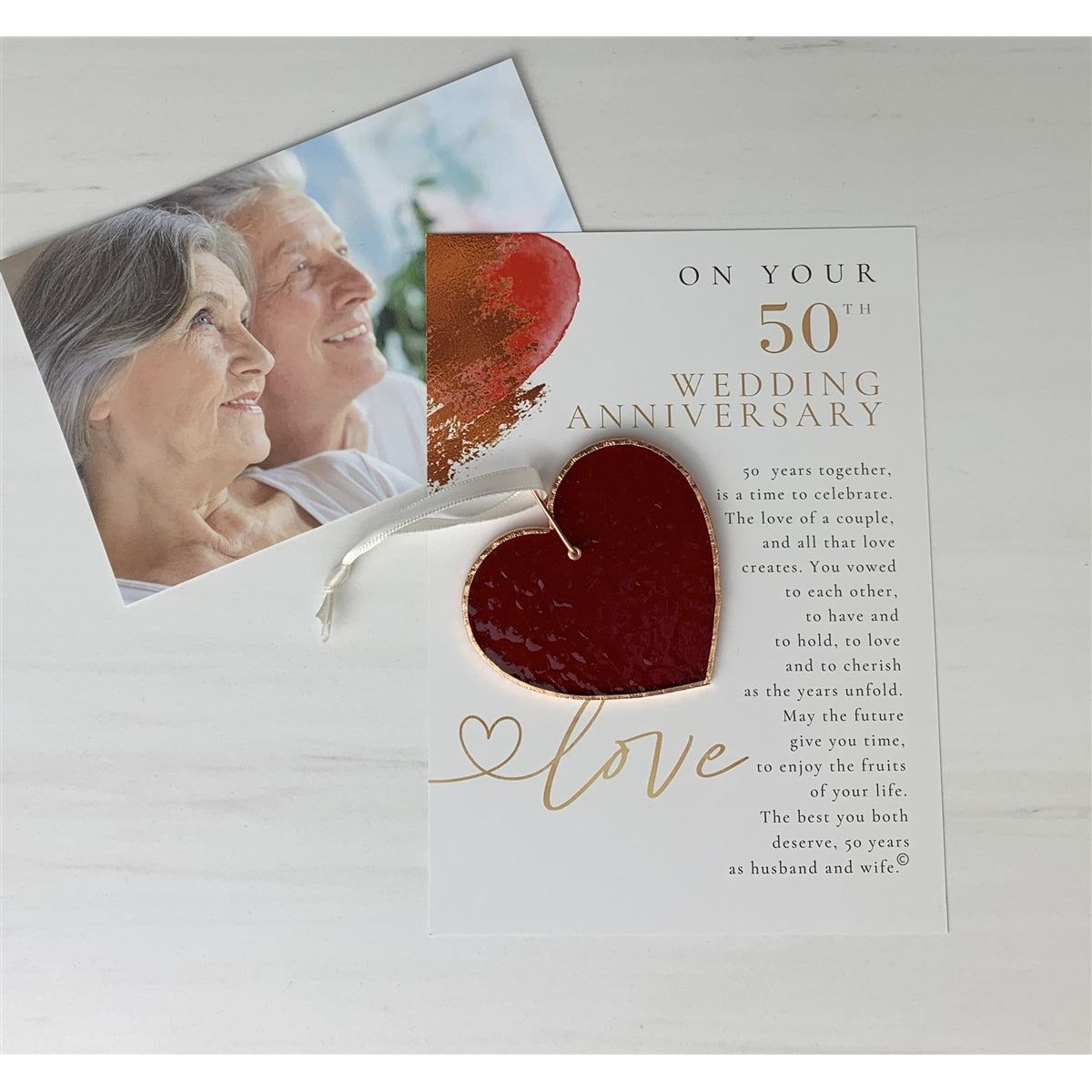 50th Wedding Anniversary gift with photo of a happy couple in background.