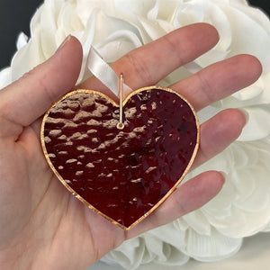 4 of 7:Red stained glass heart being held in a hand.