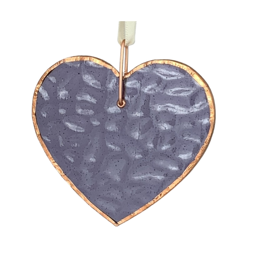 Purple glass heart with bubbles, ripples and texture inherent to handmade glass.