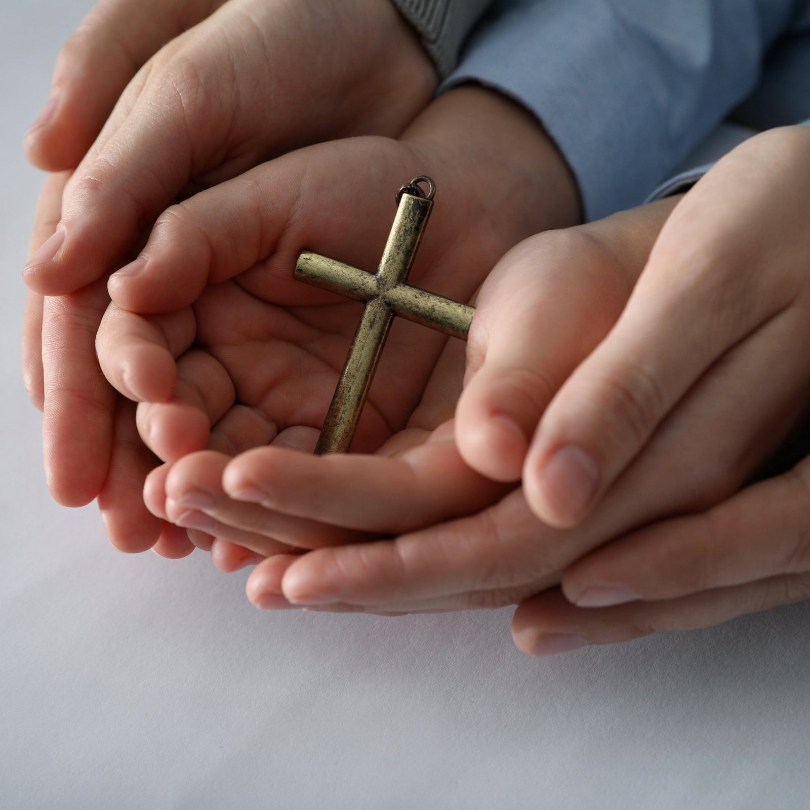 Hands cradling a cross