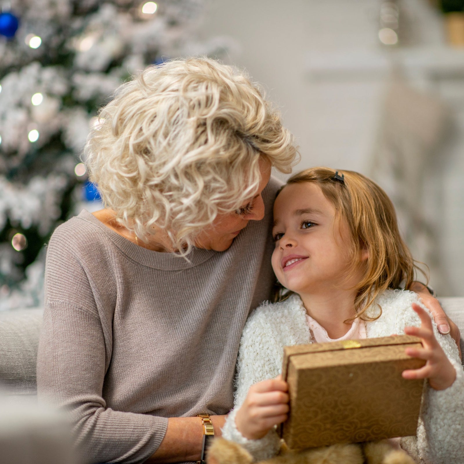 A grandmother giving her granddaughter a gift.