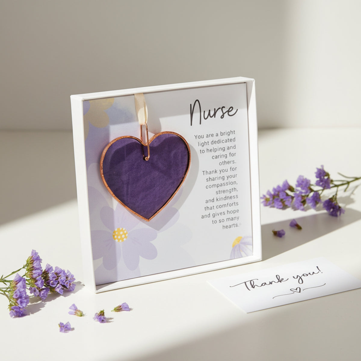 Stained glass purple heart with Nurse sentiment next to a thank you note.