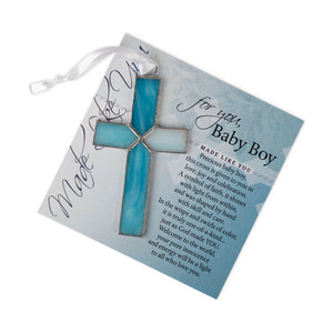 2 of 4:Light blue stained glass cross lying on the 