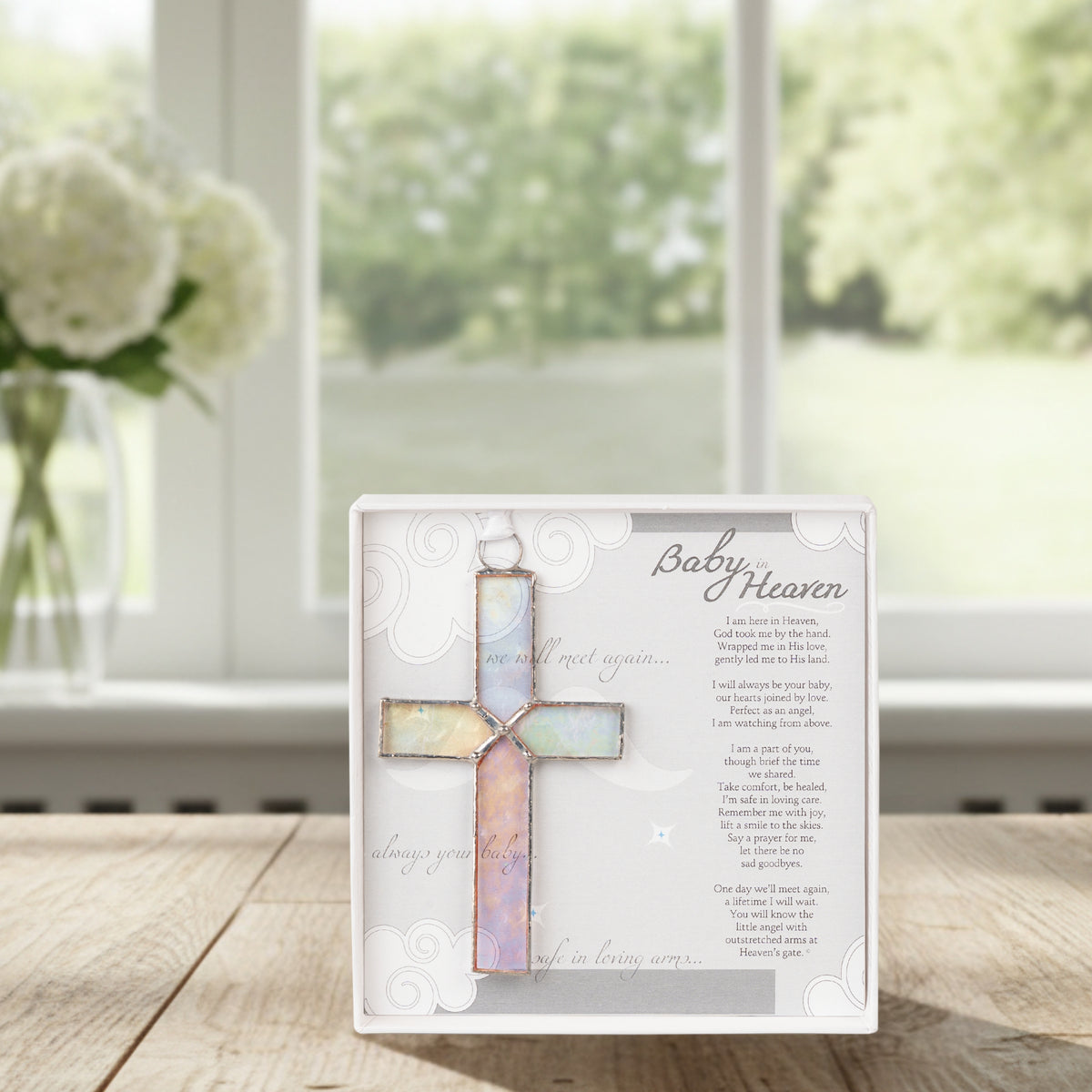 Infant loss poem and stained glass cross on a table.