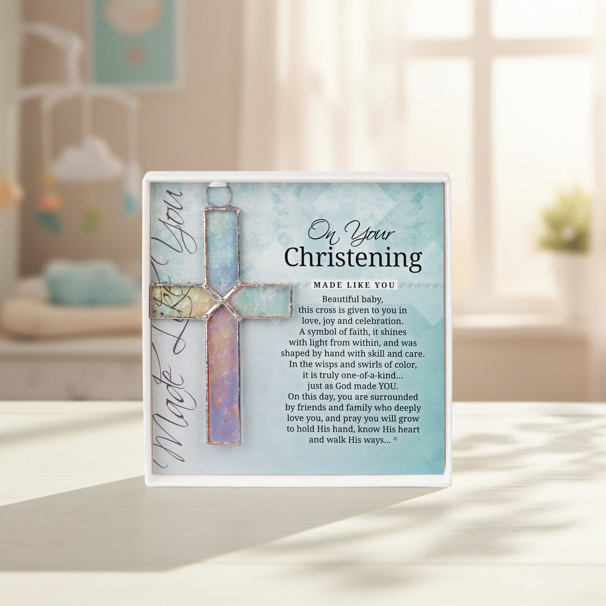 Christening cross gift on a shelf in a baby's room.