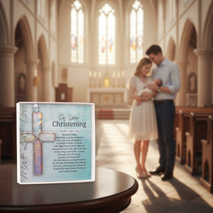 5 of 5:Cross displayed in a church with parents holding their baby in the background.
