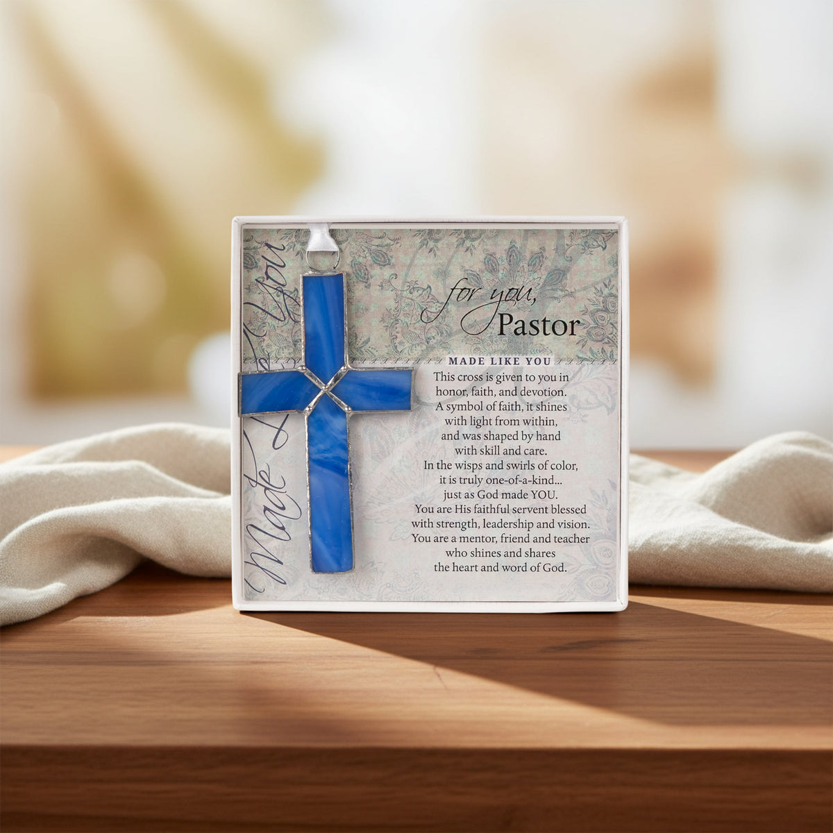 Pastor gift displayed on a table in front of a garden window.