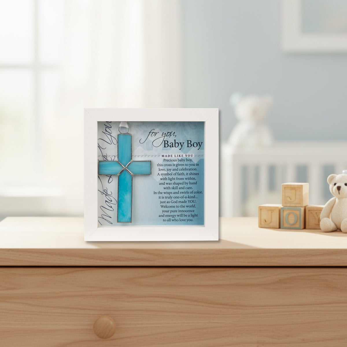 Framed Baby Boy Cross on a nursery dresser.