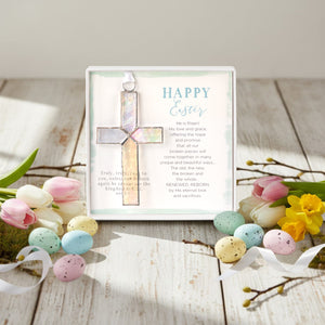 3 of 6:Clear iridescent stained glass cross and Easter sentiment on a table with Easter decor.