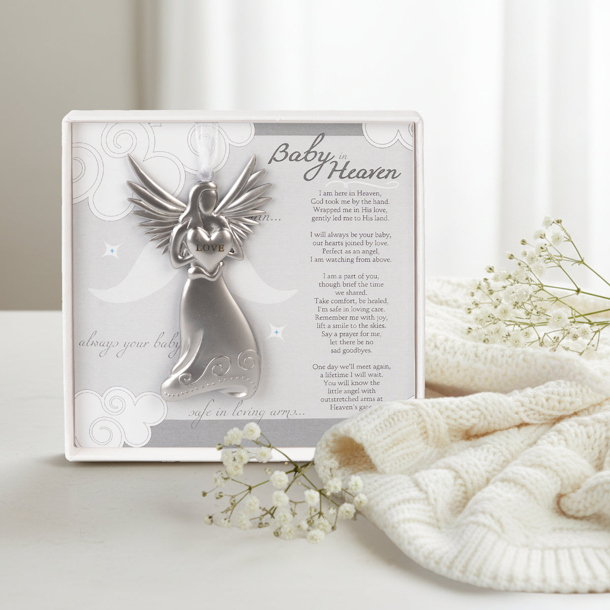 Baby in Heaven gift next to a white throw and baby's breath flowers.