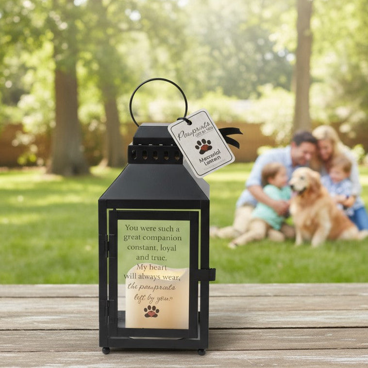 Pawprints Left by You Lantern on a table with a family and their dog in the background.