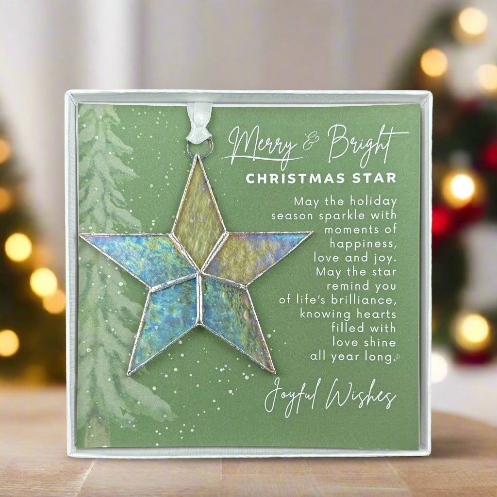 Handmade 4&quot; clear iridescent stained-glass star with silver edging, packaged with &quot;Merry &amp; Bright&quot; sentiment in white gift box with clear lid.