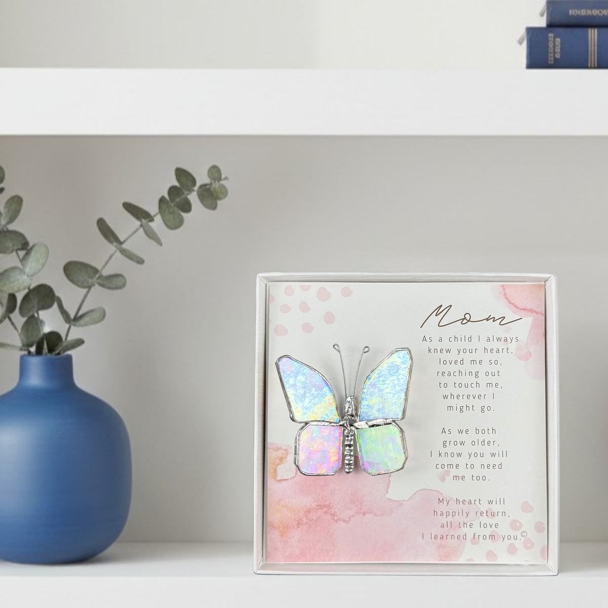 Butterfly gift for mom on a bookshelf.