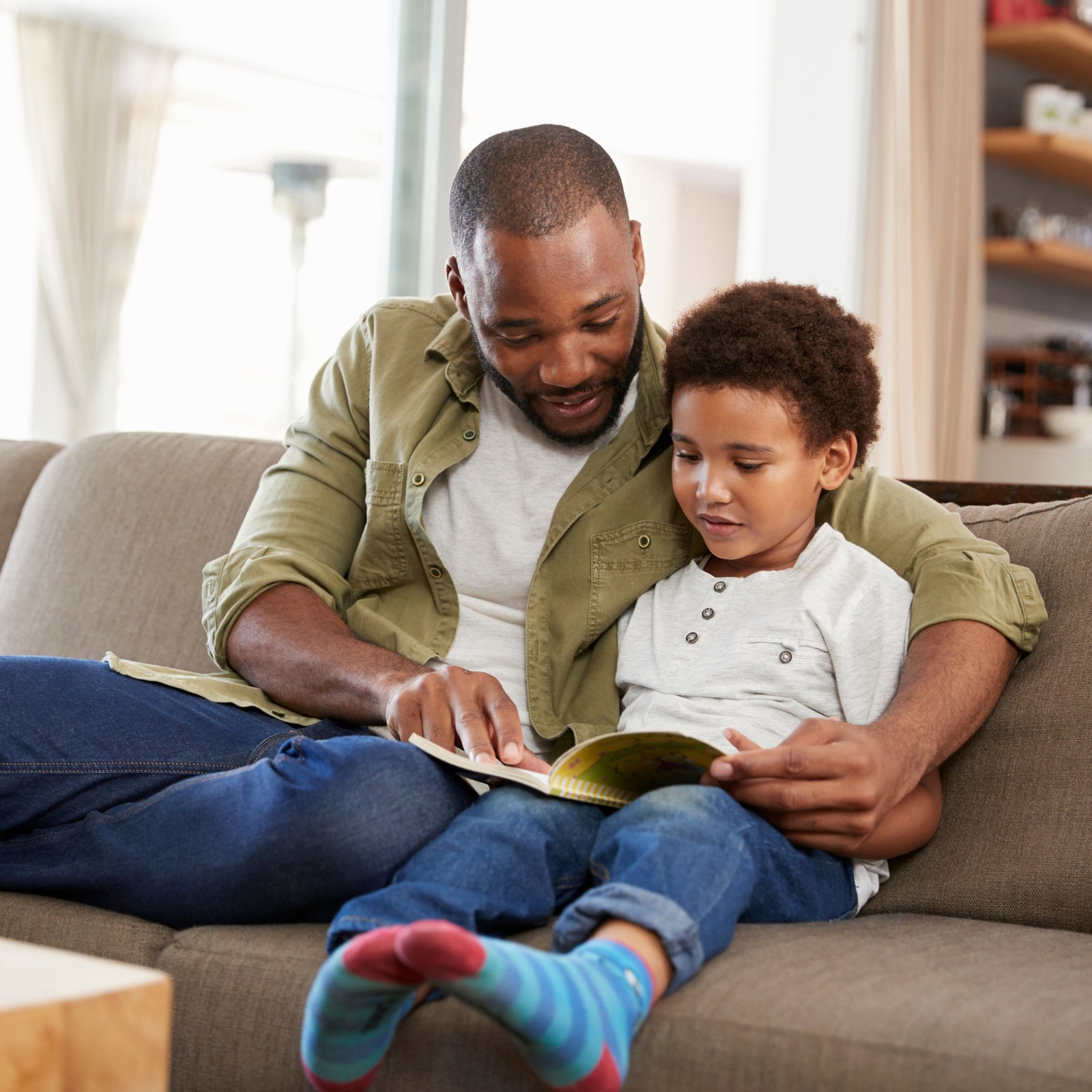 A father and son reading a book - Click to shop our Gifts for Sons and Daughters
