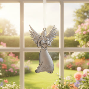 4 of 4:Silver toned metal angel hanging in front of a garden window.