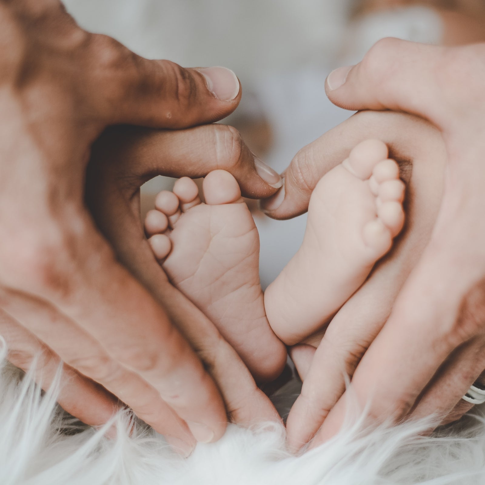Parents' hands and baby's feet forming a heart shape - Click to shop our Pregnancy and New Baby Gifts