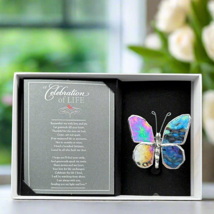 Clear iridescent butterfly in a white box with a 'Celebration of Life' card.