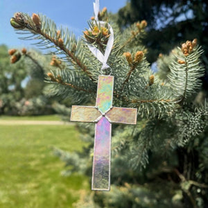 3 of 5:Clear iridescent cross hanging in the sunlight to show how the light reflects color in the glass.