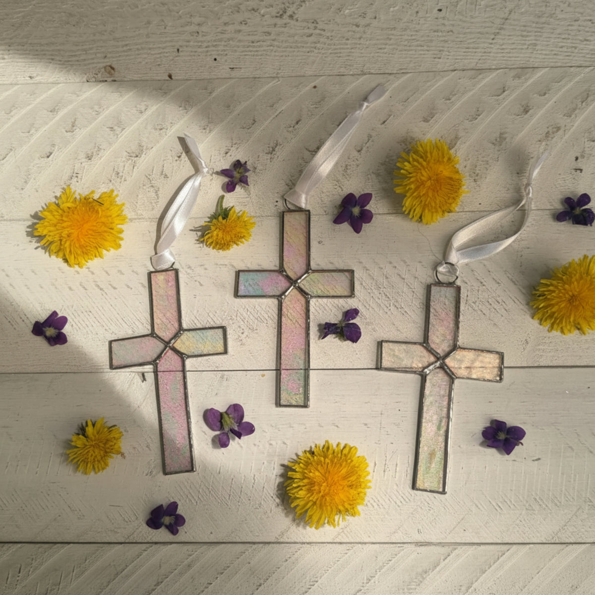 Variety of clear iridescent stained glass crosses.