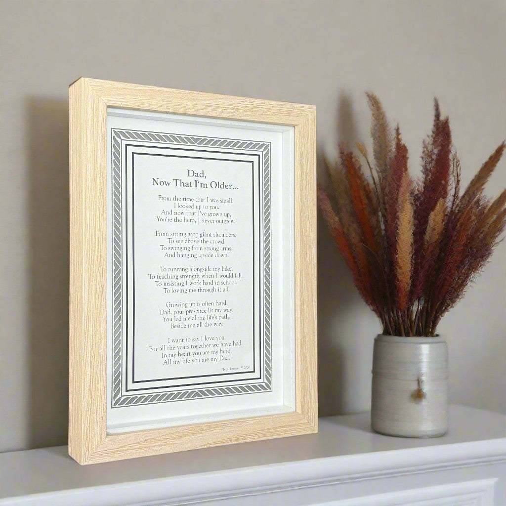 Framed poem titled &#39;Dad, Now That I&#39;m Older&#39; on a shelf with a vase of dried plants.