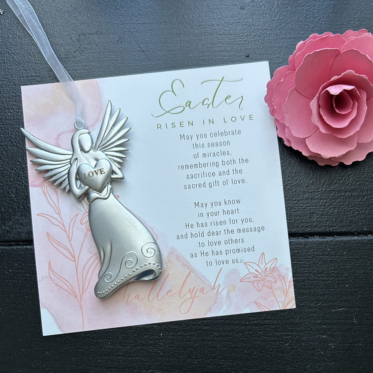 Easter Love angel with white organza ribbon for hanging.  Angel is lying on the Easter Risen in Love artwork with sentiment.