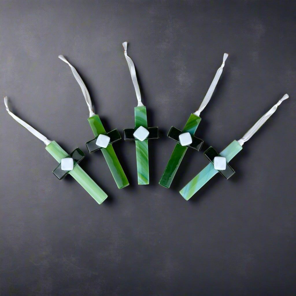 An assortment of green glass crosses showing the unique glass used for each cross.