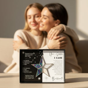 6 of 8:I Care Star on a table with two women embracing in the background.