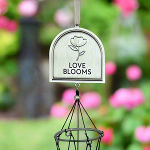3 of 5:Top of the front of the windchime with 'Love Blooms' text and flower design against a garden background.