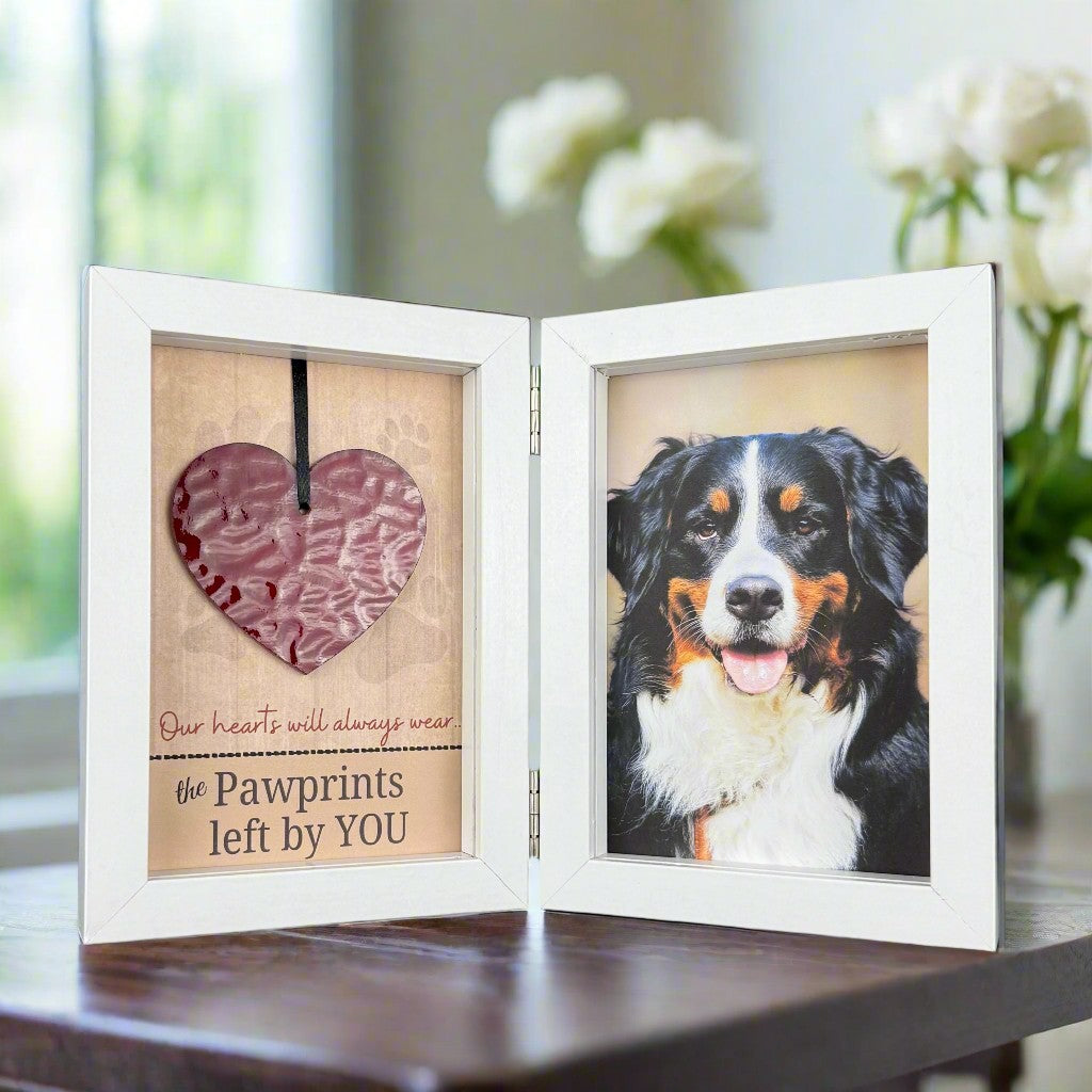 Glass heart and photo double frame on a table.
