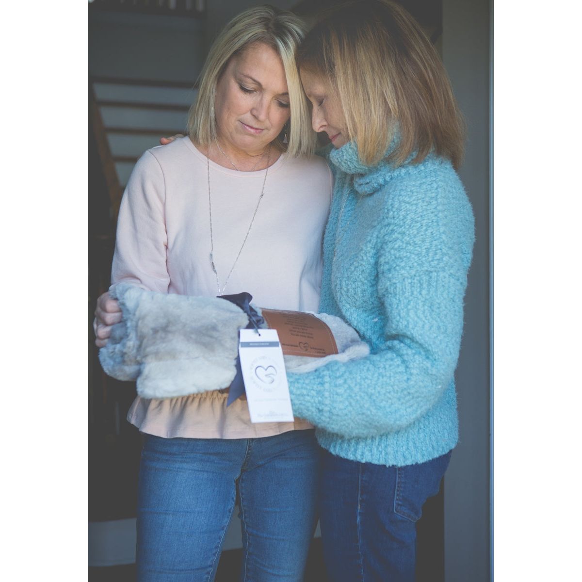 Two women exchanging the sympathy blanket gift.