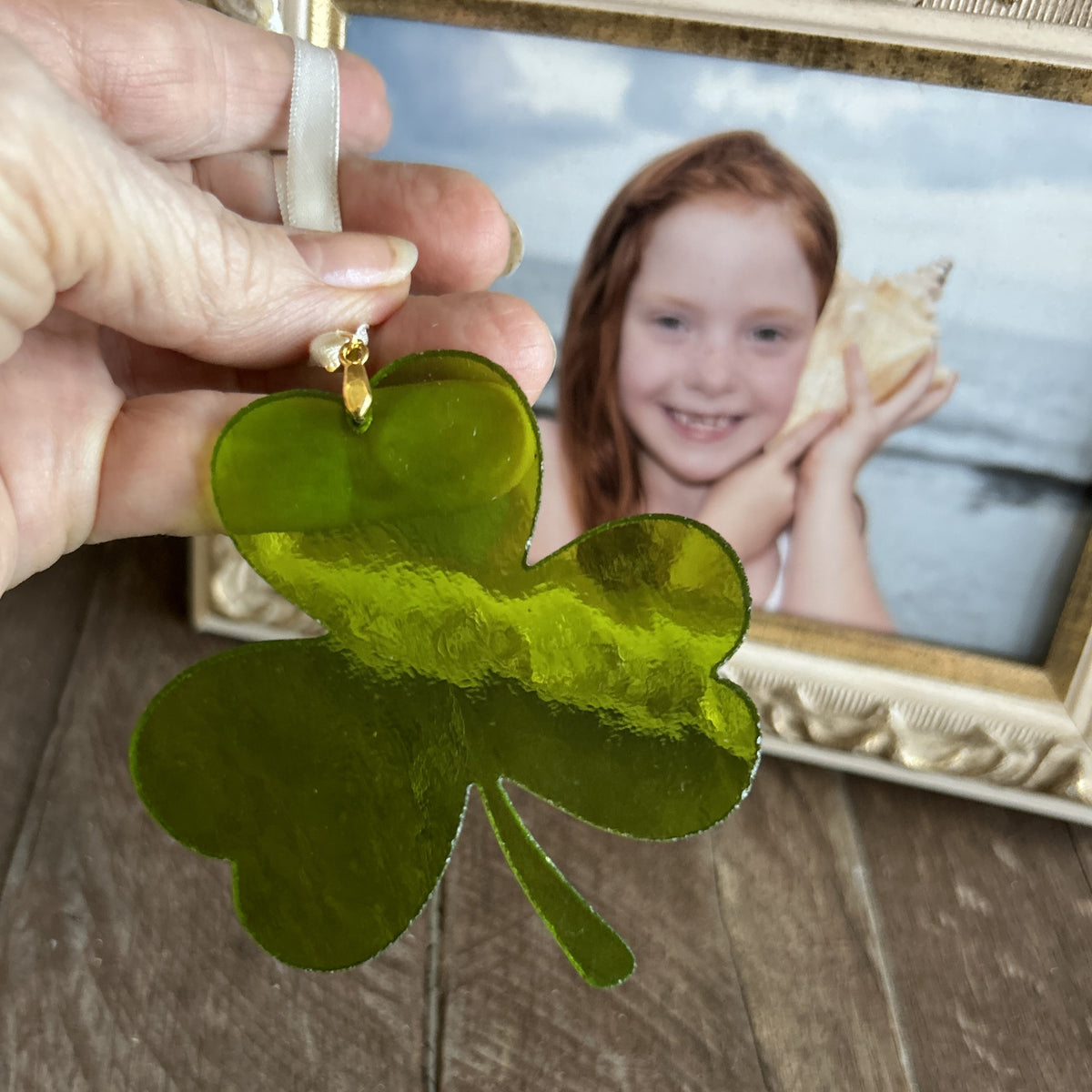 Stained glass shamrock being held to show the texture of the glass.