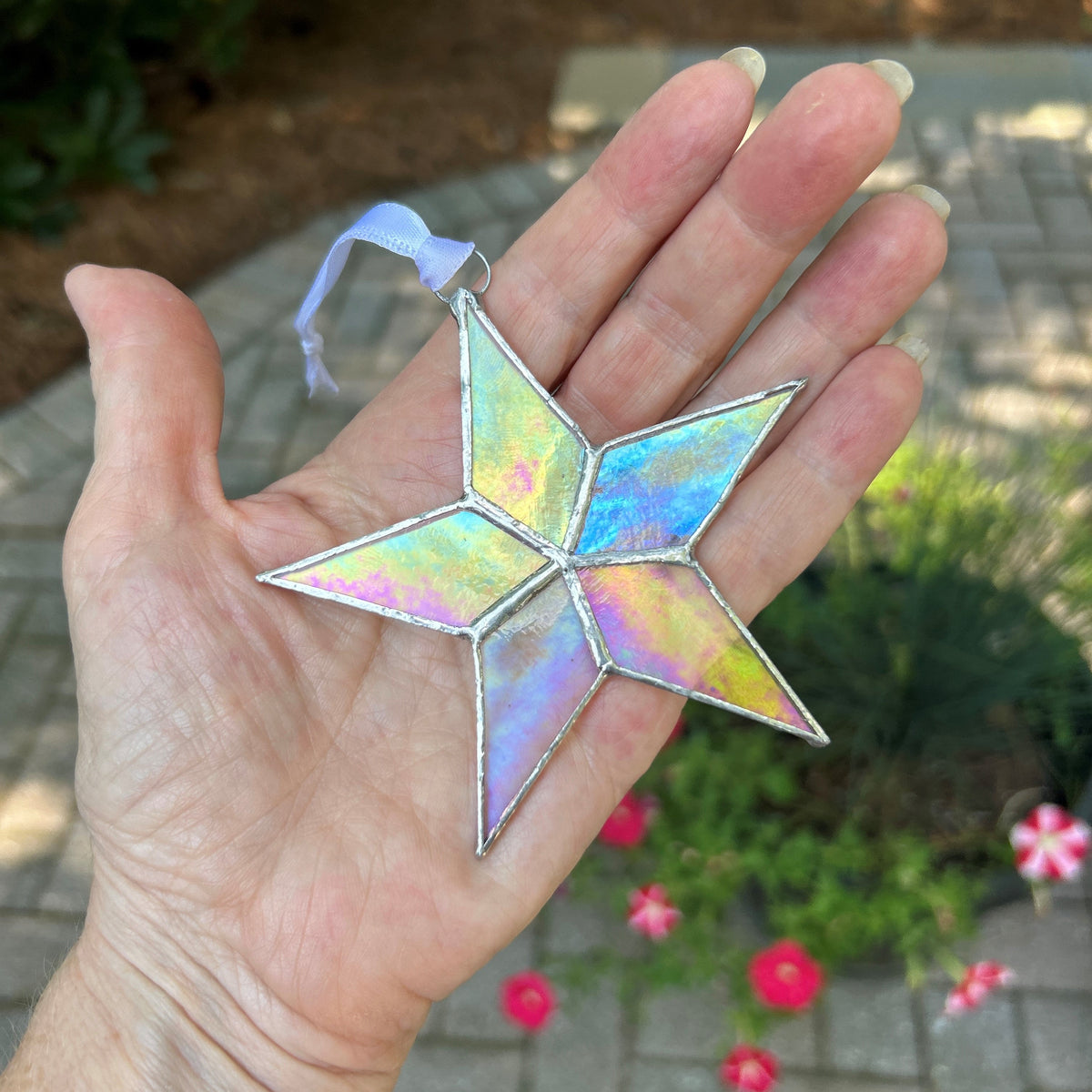Clear iridescent star held in hand.