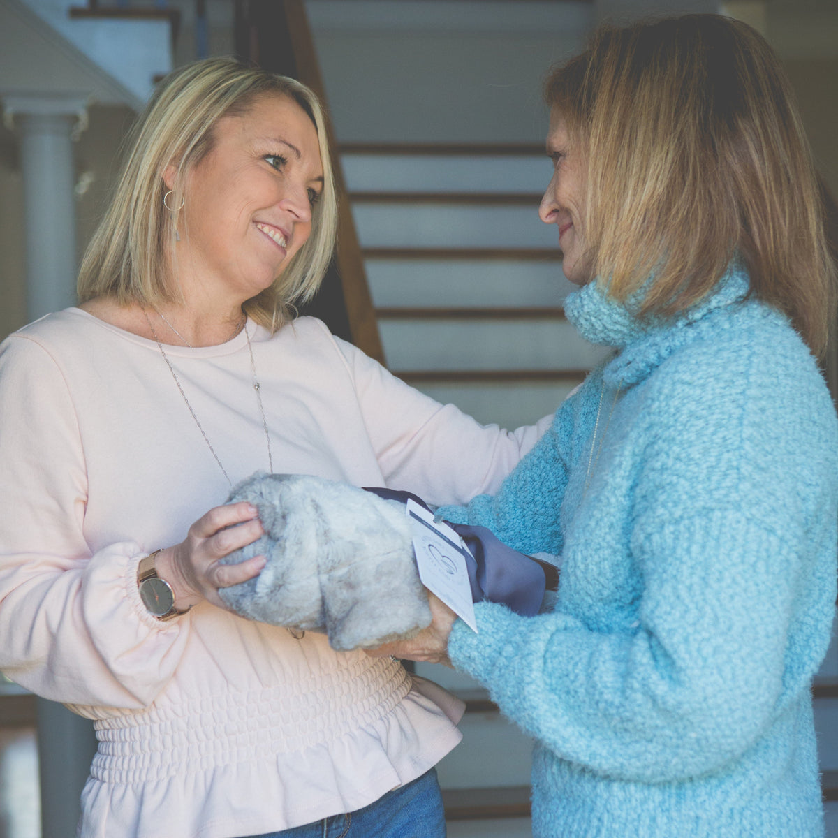 Sisters exchanging the &quot;Love You&quot; blanket.