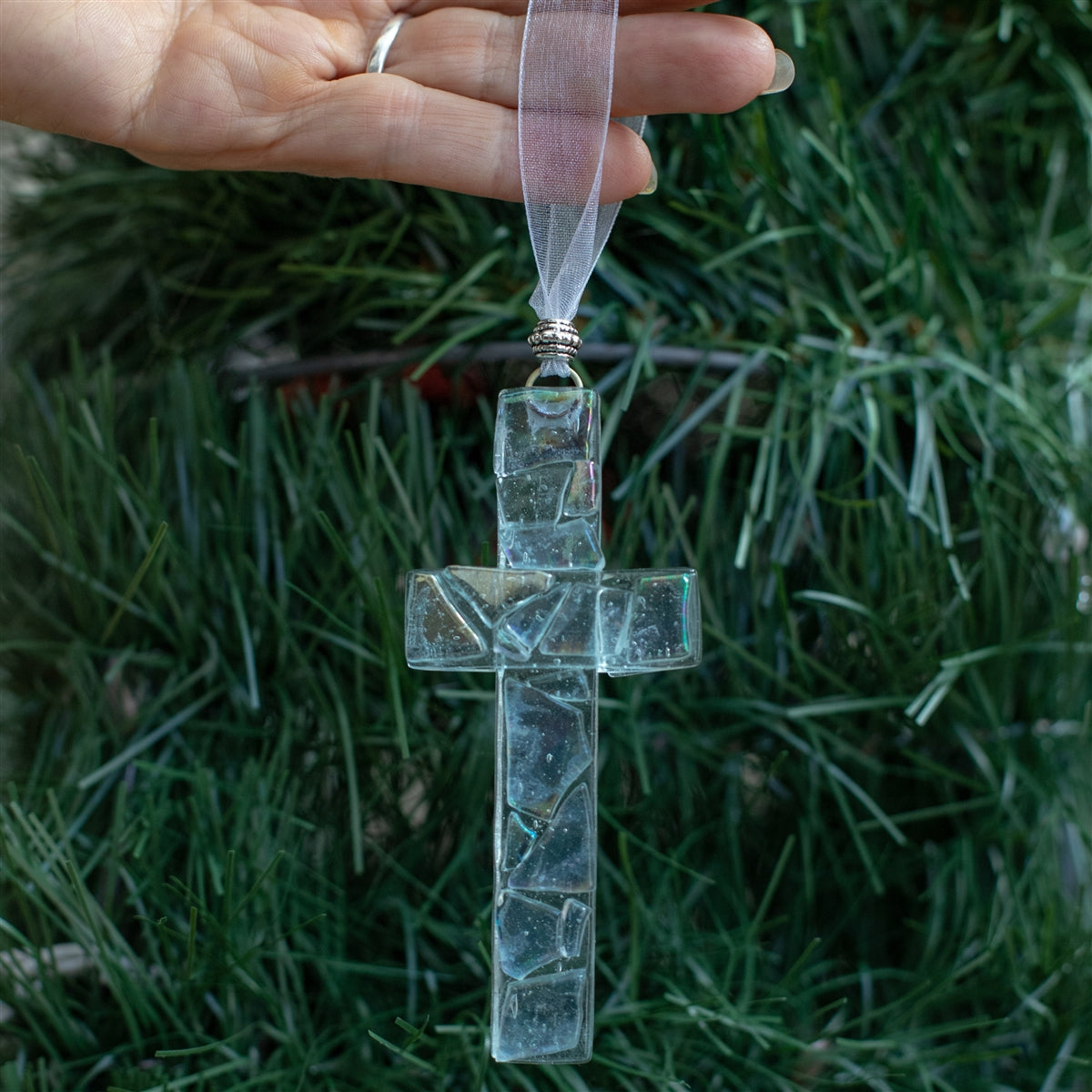 Iridescent clear mosaic cross with white organza ribbon for hanging.