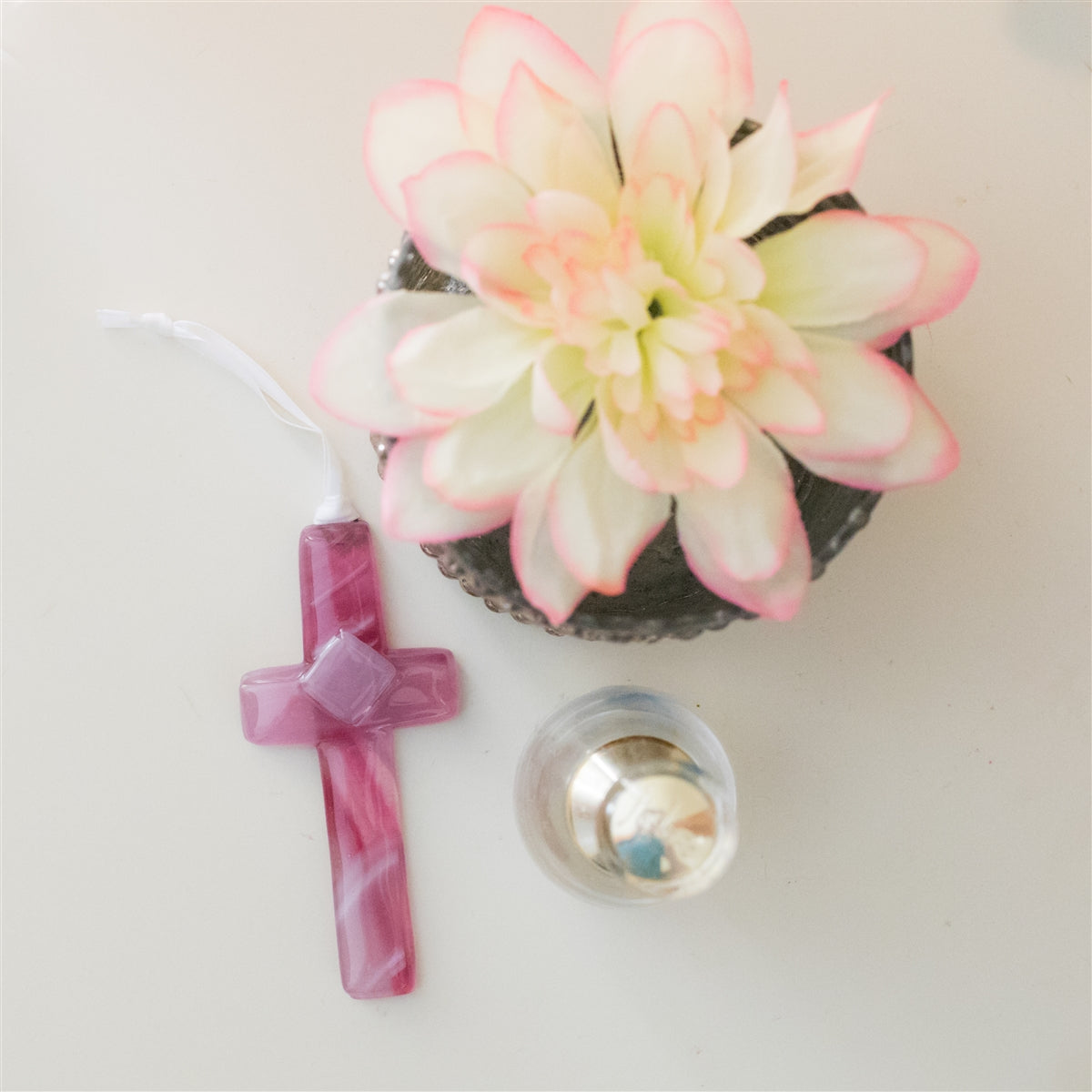 Pink glass cross with white satin ribbon for hanging.