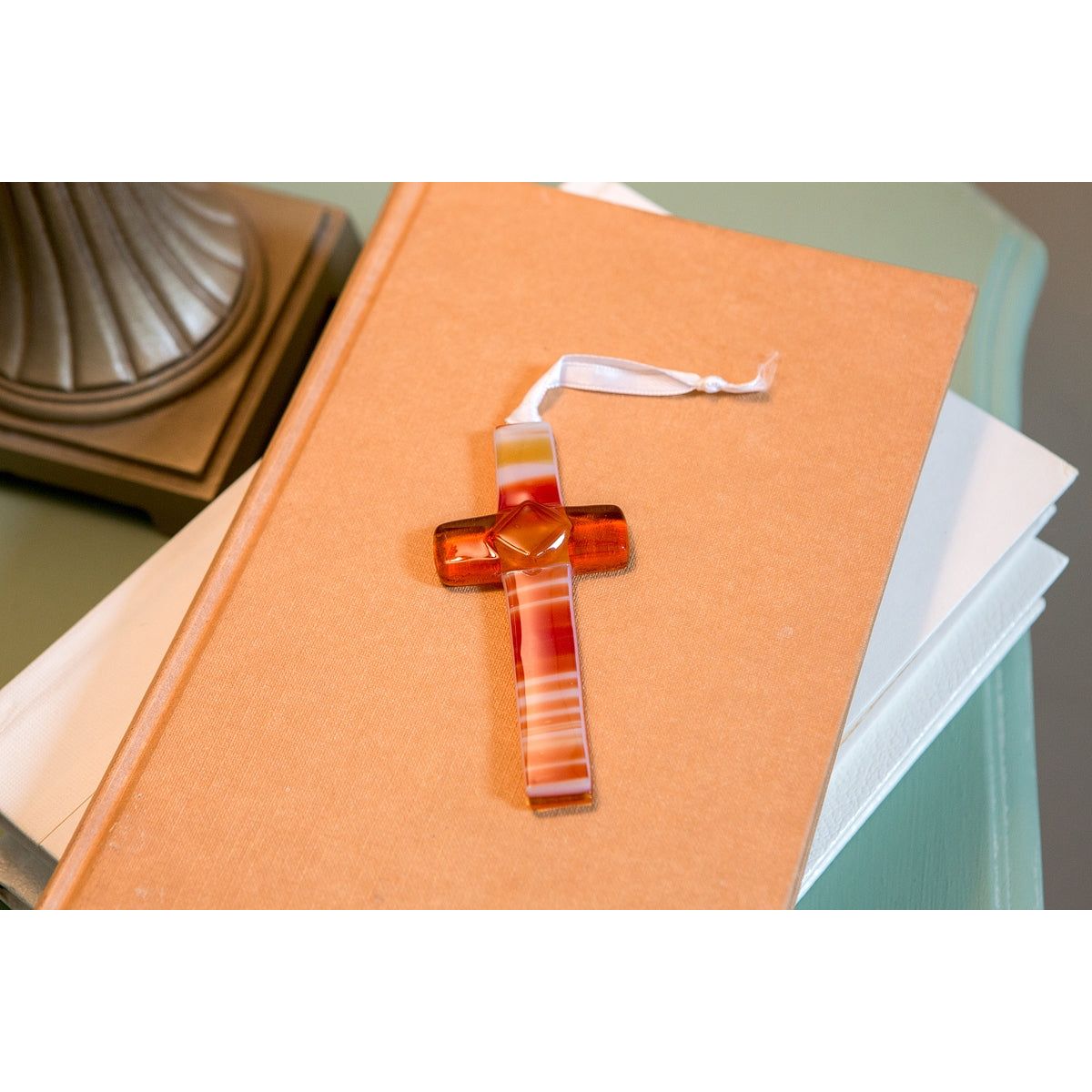 Brown/Amber cross with white satin ribbon for hangning.