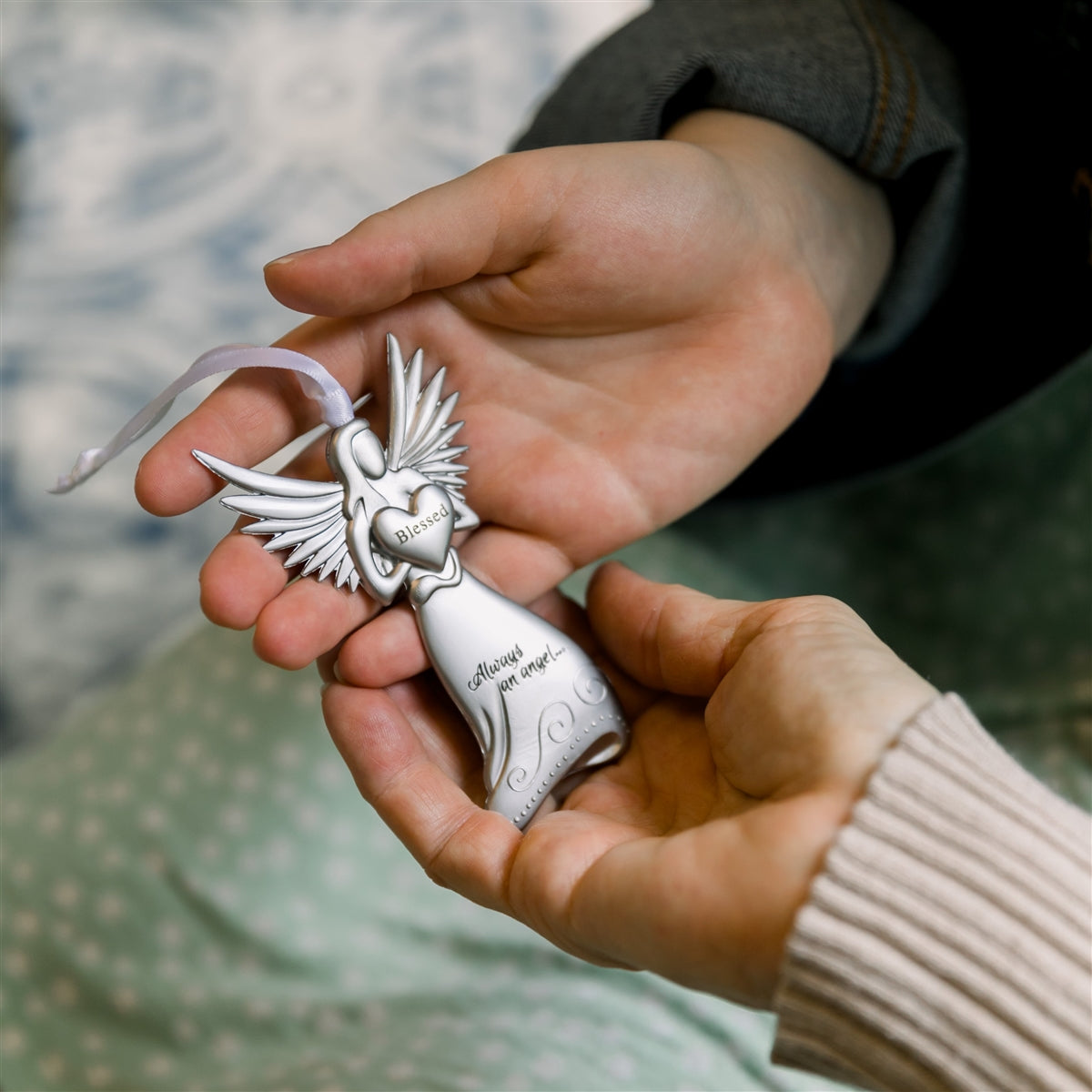 Blessed angel being exchanged between two hands.