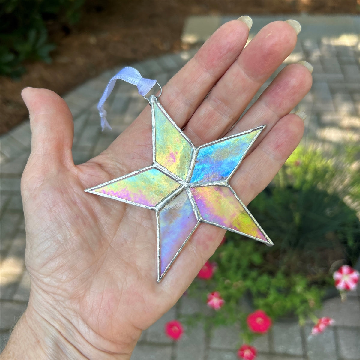 Clear iridescent star held in hand.