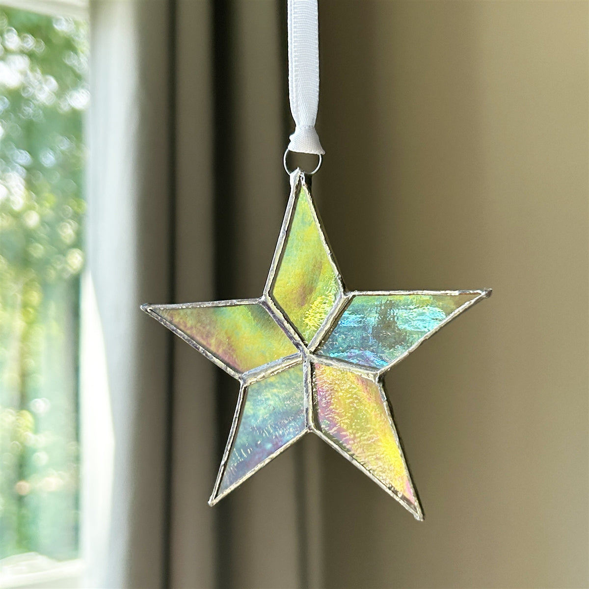 Clear iridescent star with white ribbon for hanging.